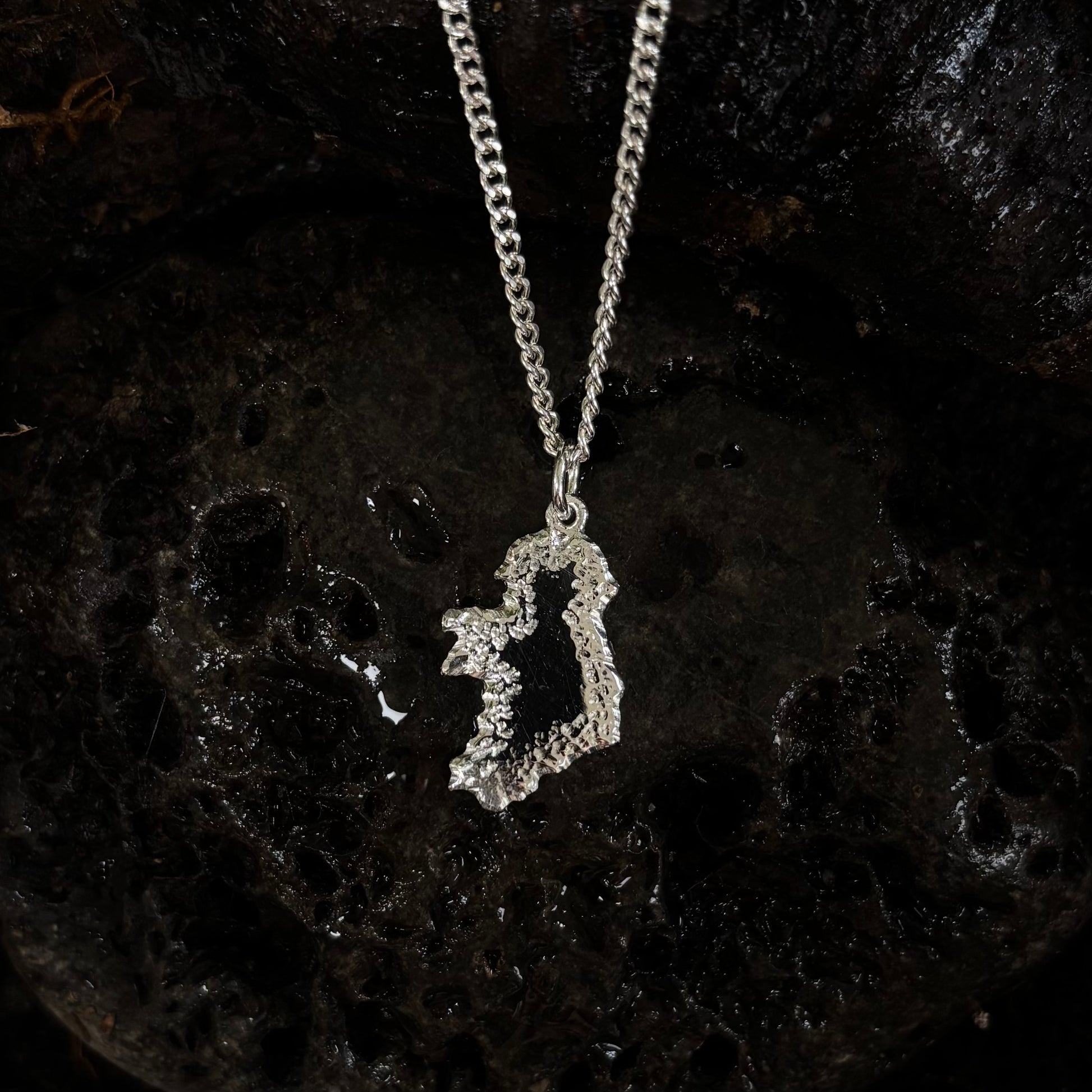 Silver Ireland shaped pendant on a dark textured background