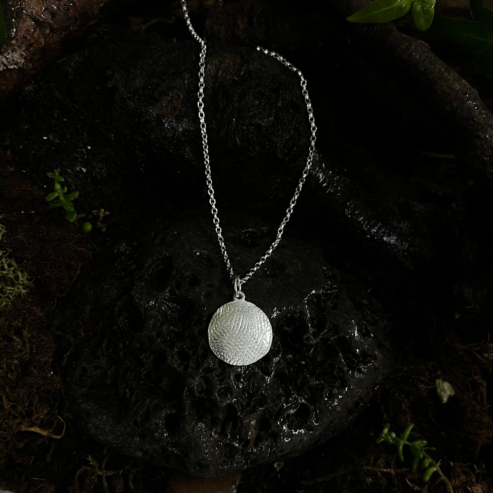 silver disc, rustic finish, hand carved